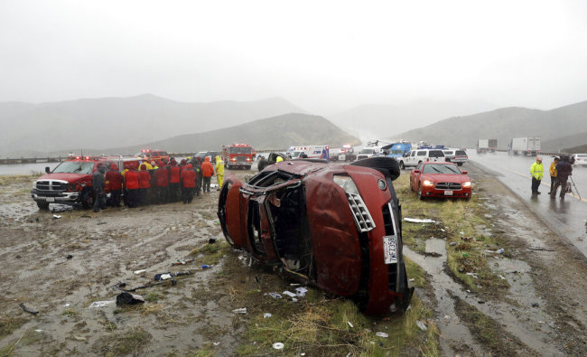 An overturned vehicle is seen at a scene of a fatal accident, where a volunteer member of the Ventura County search and rescue team was killed, along Interstate Highway 5 south of Pyramid Lake, Calif. Saturday, Feb. 2, 2019. The second in a string of powerful storms is battering California, bringing down trees, flooding roadways and prompting evacuations in wildfire burn areas where intense downpours could loosen bare hillsides and cause mudslides. [Photo: AP]
