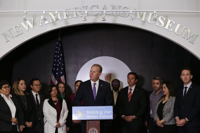 San Diego Mayor Kevin Faulconer, center, speaks during a news conference at the New Americans Museum, Monday, Feb. 4, 2019, in San Diego. Faulconer announced a new plan Monday designed to welcome immigrants and new citizens to San Diego. [Photo: AP/Gregory Bull]