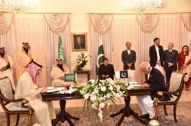 In this handout photograph taken and released by Pakistan's Press Information Department (PID) on February 17, 2019, Pakistan's Prime Minister Imran Khan (C-R) and Saudi Arabian Crown Prince Mohammed bin Salman (4L) look at their delegation members during a signing of a memorandum of understanding (MOU) at The Prime Minister House in Islamabad.[Photo: AFP]