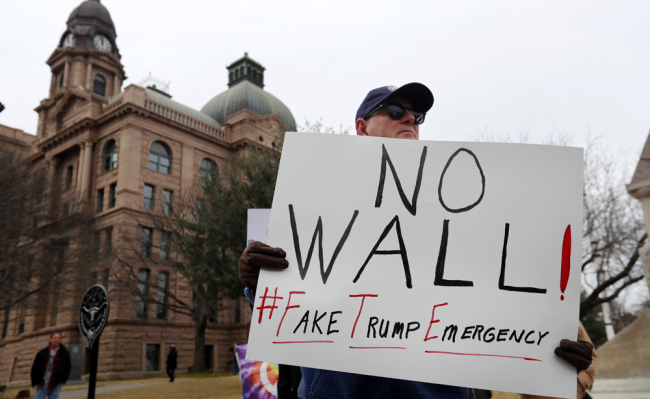 Jay Platt holds a sign during a protest in downtown Fort Worth, Texas, Monday, Feb. 18, 2019. People gathered on the Presidents Day holiday to protest President Donald Trump's recent national emergency declaration. [Photo: AP/LM Otero]