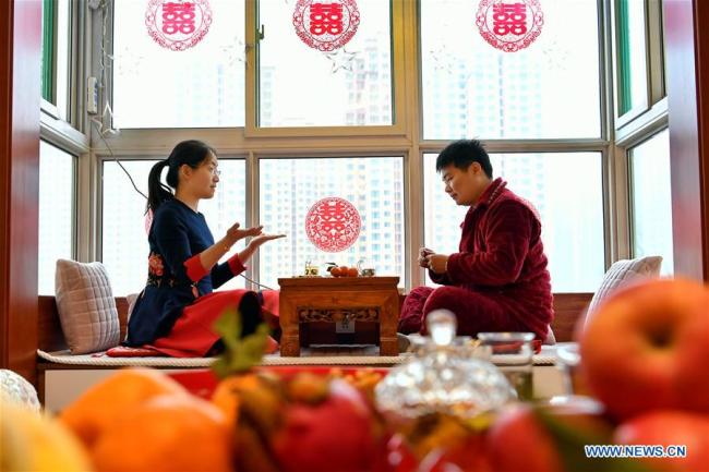 Ma Jinzhao (R) and Zhang Wenye play games(游戏 yóuxì) at home in Taiyuan, north China's Shanxi Province, Feb. 13, 2019. [Photo: Xinhua]