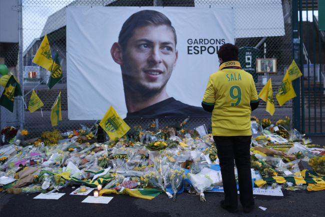 In this Wednesday, Jan. 30, 2019, file photo, a Nantes soccer team supporters stops by a poster of Argentinian player Emiliano Sala and reading "Let's keep hope" outside La Beaujoire stadium before the French soccer League One match Nantes against Saint-Etienne, in Nantes, western France.[Photo: AP] 