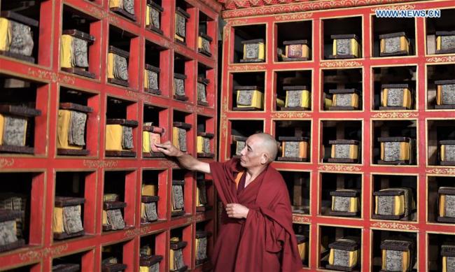 A monk of the Potala Palace arranges documents in Lhasa, capital of southwest China's Tibet Autonomous Region, Nov. 15, 2018. [Photo: Xinhua/Purbu Zhaxi]