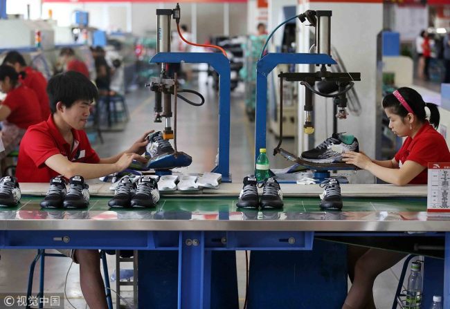 Workers sew sports shoes at a factory of a private sportswear company in Jinjiang, Fujian Province, July 27, 2016. [File photo: VCG]