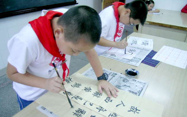 Pupils at Xiejiawan Primary School in Chongqing practice Chinese calligraphy. [Photo provided to China Plus]