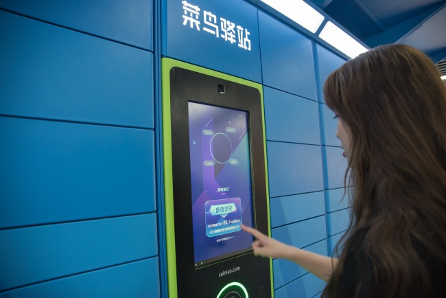 A local resident gets her parcel from a Cainiao delivery locker in the city of Hangzhou in Zhejiang Province on May 24, 2018. [File Photo: IC]