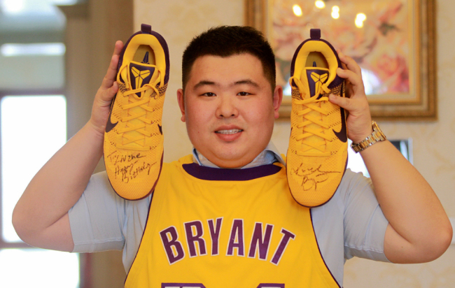 Liu Zhe shows a pair of Nike sneakers signed by the retired NBA superstar Kobe Bryant. Liu has a large collection of memorabilia signed by the NBA star at his home in Harbin, Heilongjiang Province, seen here on April 11, 2018. [File Photo: IC] 