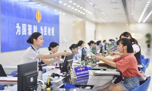 The staff members of Taxation Bureau of Quanzhou, Southeast China's Fujian Province, handling business for taxpayers on Friday. [Photo: Xinhua]