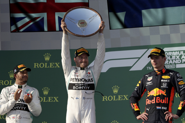 Mercedes driver Valtteri Bottas of Finland, center, lifts his trophy as he celebrates after winning the Australian Formula 1 Grand Prix as teammate Lewis Hamilton of Britain, left, and Red Bull driver Max Verstappen of the Netherlands watch in Melbourne, Australia, Sunday, March 17, 2019. Bottas won ahead Hamilton while Verstappen placed third. [Photo: AP]