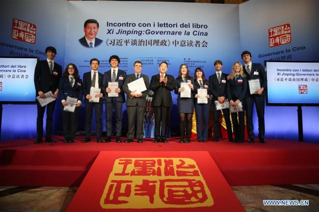 Jiang Jianguo (C), deputy head of the Publicity Department of the Communist Party of China Central Committee, and Paolo M. Reale (5th, L), president of Rome Convitto Nazionale Vittorio Emanuele II, an Italian boarding school, pose for a photo with Italian students at a seminar on "Xi Jinping: The Governance of China" in Rome, Italy, March 20, 2019. About 200 guests, including officials and political figures from China and Italy, engaged in in-depth discussions at the event, which took place on the eve of Chinese President Xi Jinping's state visit to the European nation. [Photo: Xinhua/Zheng Huansong]
