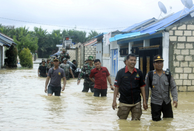 Indonesian police and soldiers search for residents who need assistance at a flooded neighborhood in Sentani, Papua Province, Indonesia, Monday, March 18, 2019. [File Photo: AP]