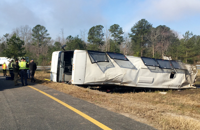 This photo provided by Virginia State Police emergency responders at the scene after a charter bus overturned on an Interstate 95 exit near Kingwood, Va., March 19, 2019. [Photo: Virginia State Police via AP]