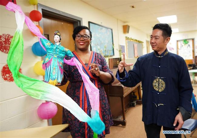 Chen Lihui (R) from Zhangzhou city in southeast China's Fujian province teaches the faculty Fujian Puppetry at Paint Branch Elementary School in the Prince George's County, Maryland, the United States, March 20, 2019. [Photo: Xinhua]