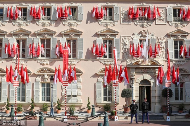 Monaco's carabinier guards stand in front of the Monaco Palace on March 22, 2019 in Monaco, where China and Monaco flags have been set on windows two days ahead of Chinese President Xi Jinping's state visit. [Photo: VCG]
