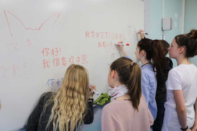 Students from the Collège Charles III of Monaco practice writing Chinese characters. [Photo: China Plus]