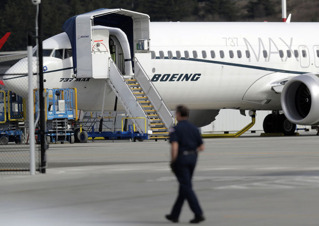 A worker walks next to a Boeing 737 MAX 8 airplane parked at Boeing Field, Thursday, March 14, 2019, in Seattle. [File photo: AP/Ted S. Warren]