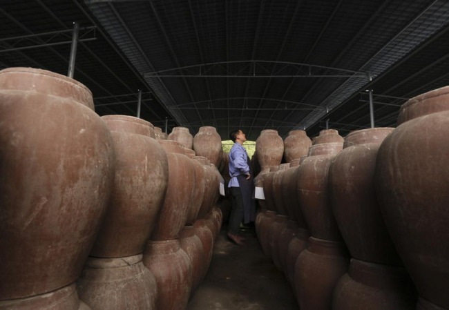 A worker checks(检查 jiǎnchá) pickle jars at a production workshop in Fuling, Chongqing, Feb 21, 2019. [Photo/Xinhua] 