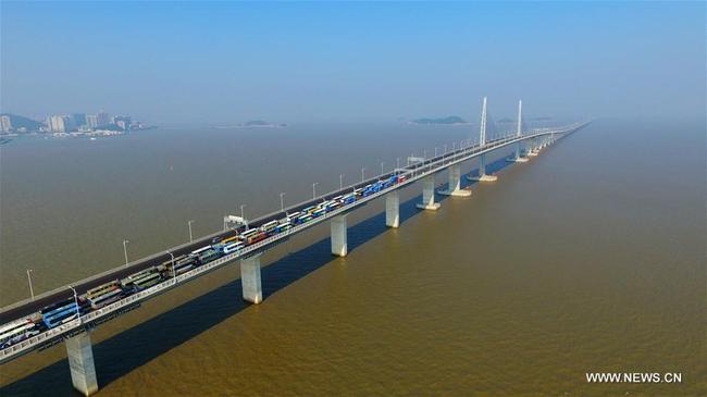 Aerial photo taken on Dec. 31, 2017 shows buses and vans running on the Hong Kong-Zhuhai-Macao Bridge, south China's Guangdong Province, to celebrate that the major work of the Bridge is completed. [Photo: Xinhua]