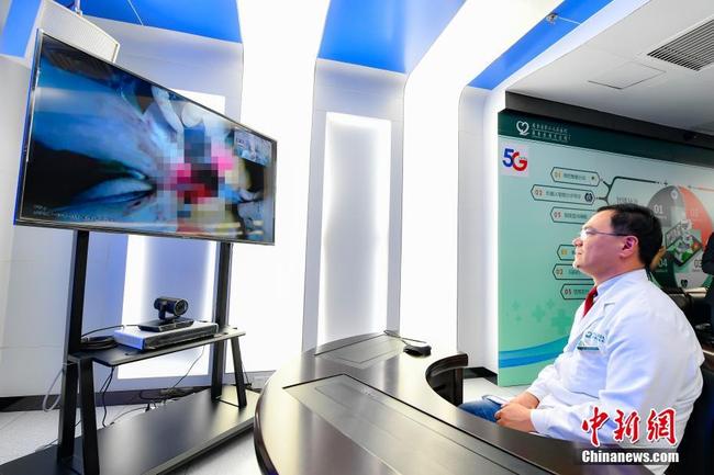 A doctor at Yangshan Hospital in rural Yangshan County in Guangdong Province watches the surgery being performed at a hospital in the provincial capital 200 kilometers away on Monday, April 1, 2019. [Photo: Chinanews.com]