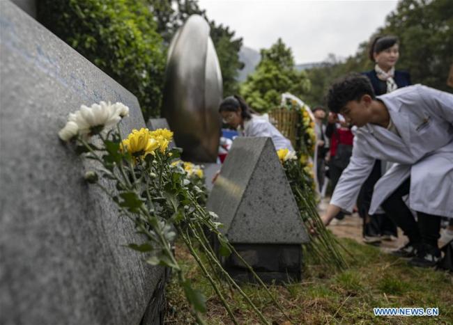 Medical worker representatives(代表 dàibiǎo) lay flowers(鲜花 xiānhuā) in front of a monument(纪念碑 jìniànbēi) in honour of organ donors during a commemorative event held at a human organ donor memorial park in Kunming, southwest China's Yunnan Province, April 3, 2019. [Photo: Xinhua]