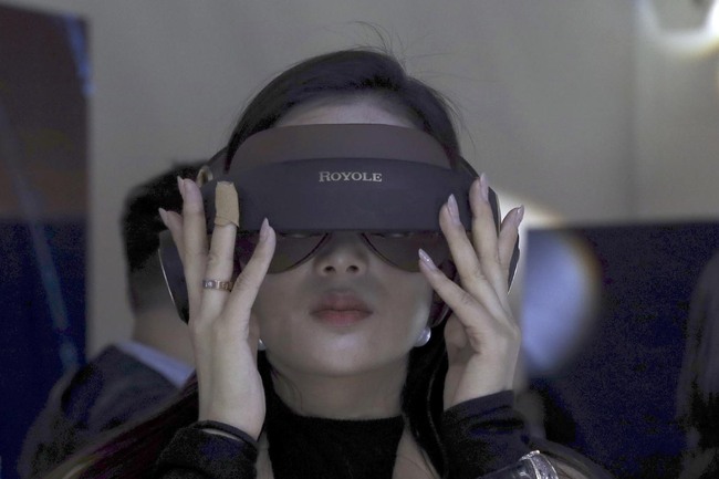 In this Wednesday, Oct. 31, 2018, photo, a visitor tries out a virtual reality goggle from Royole Corporation during an event to unveil what is described as the world's first commercial foldable smartphone in Beijing. [Photo: AP]