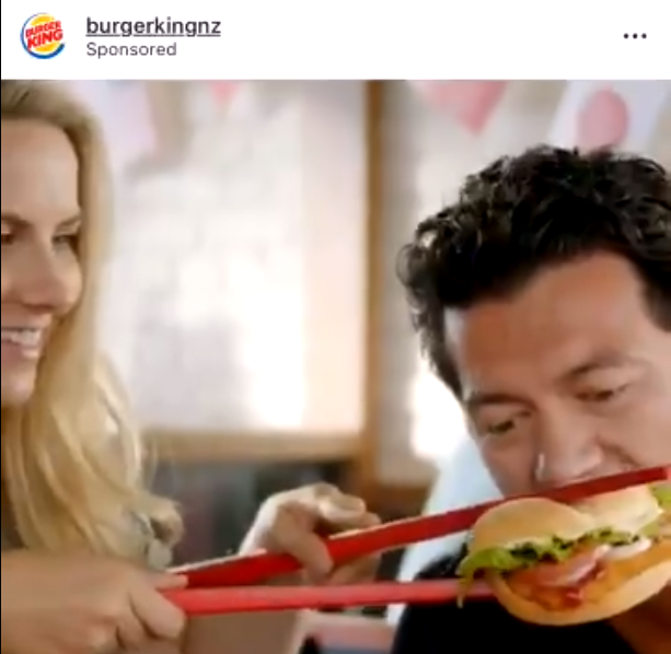 A screen shot from Twitter shows the video ad published by Burger King showing a customer eating a hamburger with oversized chopsticks. [Photo: thepaper.com]