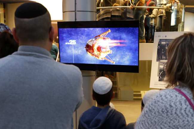 People watch a screen showing explanations of the landing of Israeli spacecraft, Beresheet's, at the Planetaya Planetarium in the Israeli city of Netanya, on April 11, 2019 before it crashed during the landing.[Photo: AFP/JACK GUEZ] 