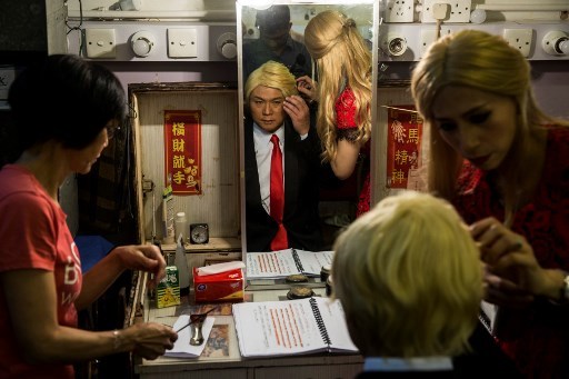 Actress Man Chan (R), dressed as Ivanka Trump, helps actor Loong Koon-tin (C), changes into US President Donald Trump back stage during a rehearsal of a Cantonese opera called "Trump on Show" in Hong Kong on April 11, 2019. [Photo:AFP]