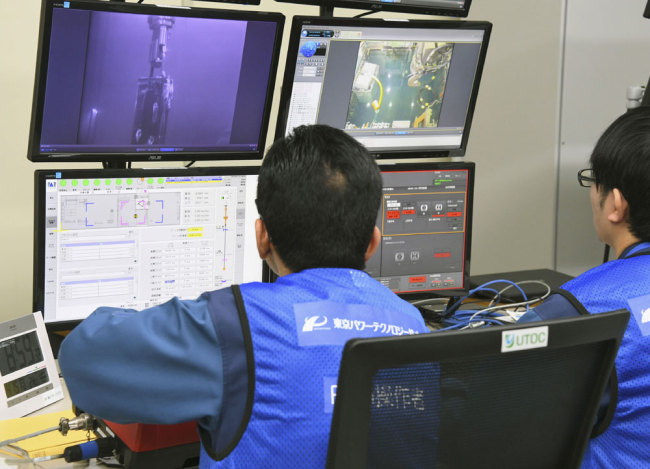 Tokyo Electric Power Co. workers remotely make operation for removing fuels at Unit 3 of Fukushima Dai-ichi nuclear plant, in Okuma, Fukushima Prefecture, northeastern Japan Monday, April 15, 2019. [Photo: Kyodo News via AP]