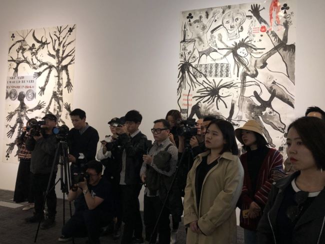 Journalists look on as a group of visitors observe the exhibition, which opened in Beijing on Sunday, April 14, 2019. [Photo: China Plus]