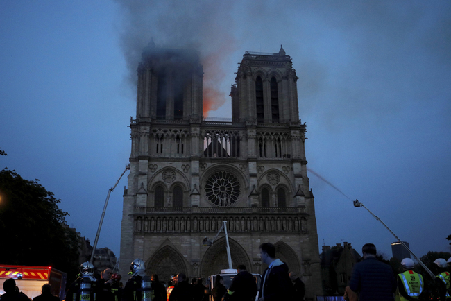 Smoke and flames fill the sky as a fire burns at the Notre Dame Cathedral during the visit by French President Emmanuel Macron in Paris, Monday, April 15, 2019. [Photo: AP]