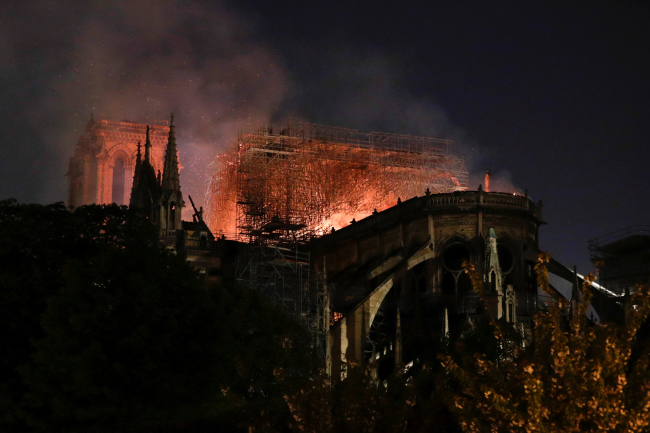 Firefighter douse flames billowing from the roof at Notre-Dame Cathedral in Paris on April 15, 2019. [Photo: AFP]