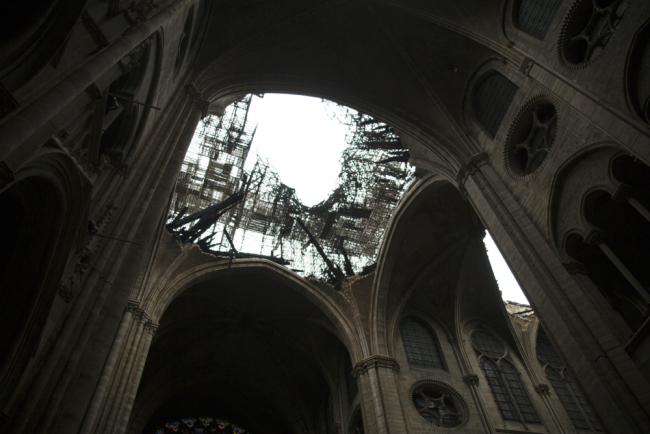 A photo shows the damaged roof of Notre-Dame-de Paris Cathedral in Paris on April 16, 2019, a day after a fire that devastated the building in the center of the French capital. [Photo: AFP/Amaury Blin]
