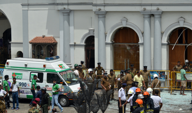 An ambulance is seen outside the church premises with gathered security personnel following a blast at the St. Anthony's Shrine in Kochchikade, Colombo on April 21, 2019. [Photo: AFP]