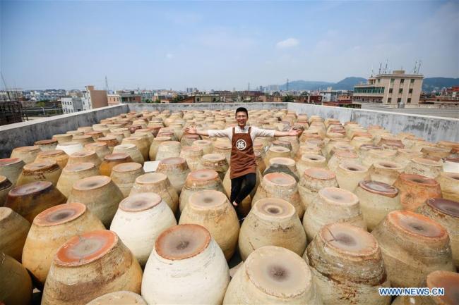 Wu Huaqing shows(展示 zhǎnshì) jars(缸 gāng) he collected for making soy sauce at his company in Quanzhou, southeast China's Fujian Province, April 29, 2019.[Photo: Xinhua]