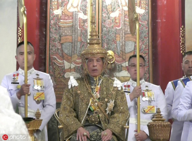 In this image made from the video, Thailand’s King Maha Vajiralongkorn, center, sits on the throne as he is officially crowned king at the Grand Palace, Saturday, May 4, 2019, in Bangkok, Thailand. [Photo: IC]