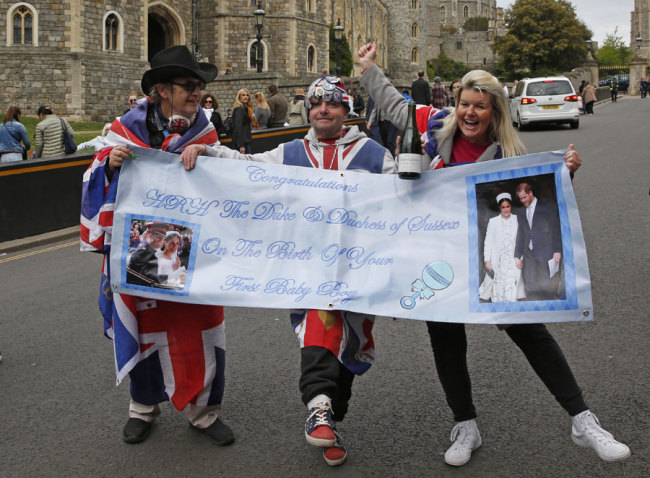 Royal super fans hold a banner congratulating Britain's Prince Harry, Duke of Sussex, and his wife Meghan, Duchess of Sussex, on the birth of their baby boy, outside of Windsor Castle in Windsor, west of London on May 6, 2019. [Photo: AFP]