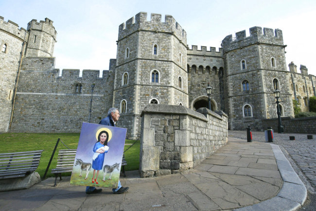 Political artist Kaya Mar walks with his latest work past Windsor Castle in Windsor, England, following the announcement of the birth of a baby boy to Britain's Prince Harry and Meghan, the Duchess of Sussex, Tuesday, May 7, 2019. [Photo: AP]