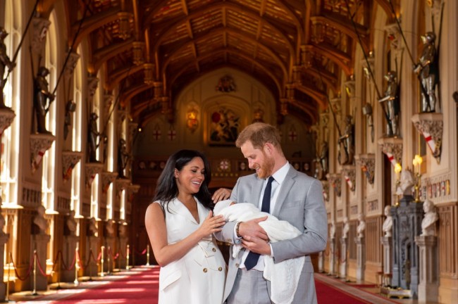 Britain's Prince Harry, Duke of Sussex, and his wife Meghan, Duchess of Sussex, pose for a photo with their newborn baby son in St George's Hall at Windsor Castle in Windsor, west of London on May 8, 2019. [Photo: AFP/Dominic Lipinski]