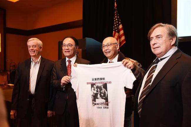 Chinese Consul General in San Francisco Wang Donghua (2nd L), Jeffrey Greene (1st R), Chairman of the Sino-American Aviation Heritage Foundation, and other guests present a T-shirt with the forum theme of "Honoring Our Father's Flags" at the 4th Sino-American Second World War Friendship and Flying Tiger History Conference in Las Vegas, the United States, May 10, 2019. [Photo: Xinhua/Han Fang]