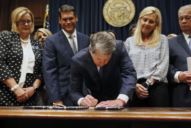 In this May 7, 2019, file photo, Georgia's Republican Gov. Brian Kemp, center, signs legislation in Atlanta, banning abortions once a fetal heartbeat can be detected, which can be as early as six weeks before many women know they're pregnant. Georgia became the fourth state to enact the ban on abortions after a fetal heartbeat can be detected. [File Photo: AP]