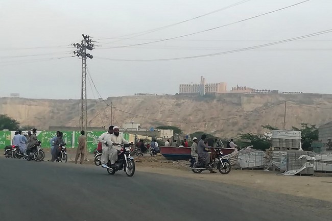 Pakistani residents watch from a road the five-star Pearl Continental hotel, located on a hill (top back) in the southwestern Pakistani city of Gwadar, on May 11, 2019. [Photo: AFP]