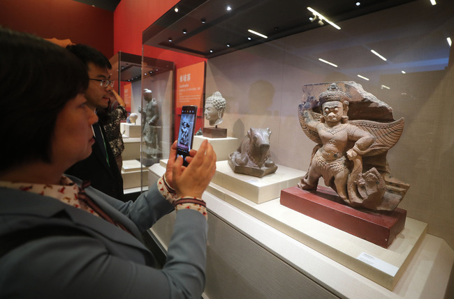 Visitors take pictures at Splendor of Asia: An Exhibition of Asian Civilizations. [Photo: VCG]