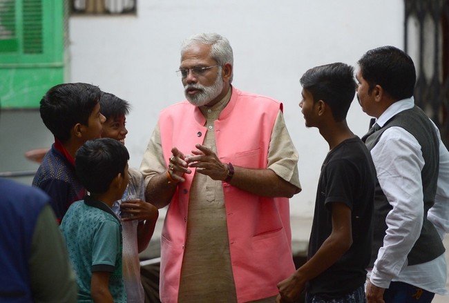 Abhinandan Pathak, a lookalike of Indian Prime Minister Narendra Modi, speaks with youths on April 17, 2019 as he campaigns in a national election bid as an independent candidate in Lucknow in India's Uttar Pradesh state. [Photo: AFP]