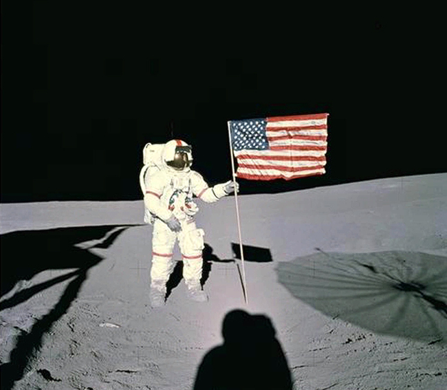 U.S. astronaut Alan B. Shepard stands with the American flag on lunar surface in February 1971. Shepard was the first American to fly in space and the fifth human to walk on the moon. [File photo: NASA via AP]