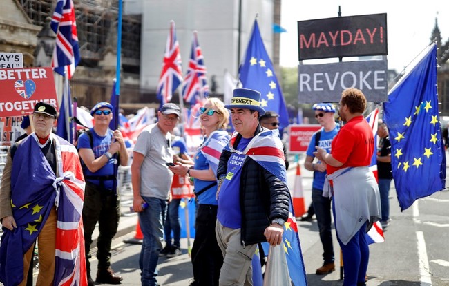 Anti-Brexit activists hold EU and Union flags as they demonstrate outside Houses of Parliament in London on May 15, 2019. [Photo: AFP/Tolga Akmen]