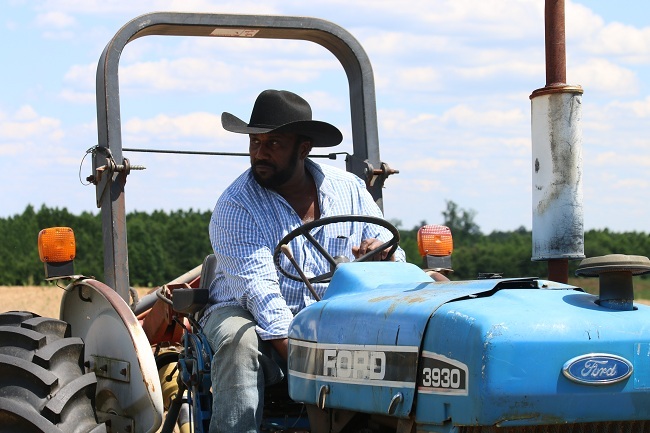 John Boyd, a fourth generation soybean farmer, operates a tractor on his farm in Baskerville, Virginia, on May 15th, 2019. [Photo: China Plus/Liu Kun]