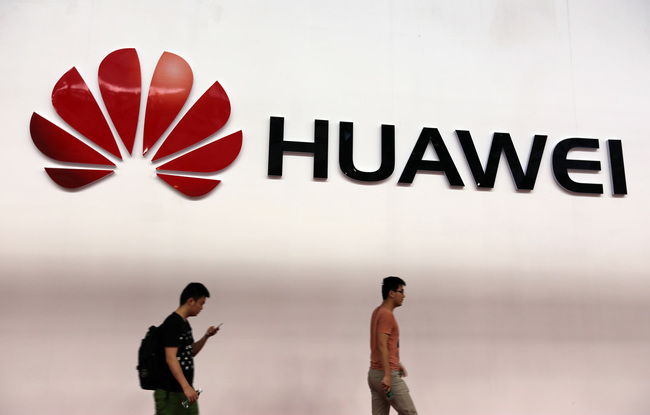 Pedestrians walk past an advertisement of Huawei during an exhibition in Guangzhou city, southeast Chinas Guangdong province, June 21, 2013. [Photo: IC]<br/><br/>