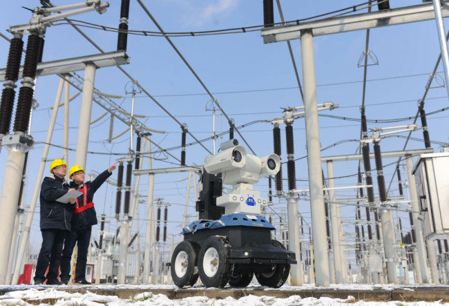 Two men analyze data of a robot at a transformer substation in Anhui. [File photo: IC]