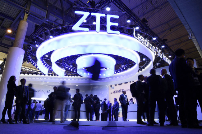 People walk past the ZTE stand at the Mobile World Congress (MWC) in Barcelona on February 25, 2019. [Photo: AFP]<br/>